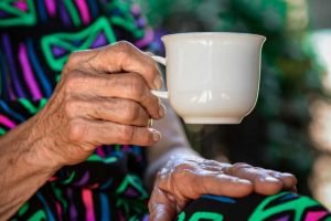 Elderly person holding a teacup