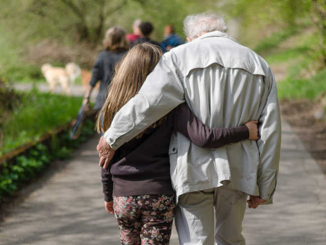 Elderly man and girl walking together
