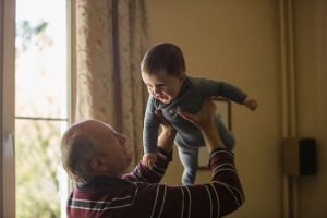 elderly man at home with his grandson