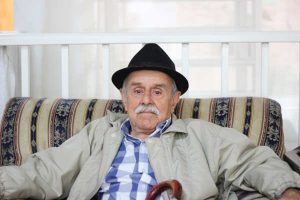 elderly man sitting on a couch at home