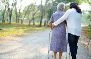 caregiver walking outside with elderly woman