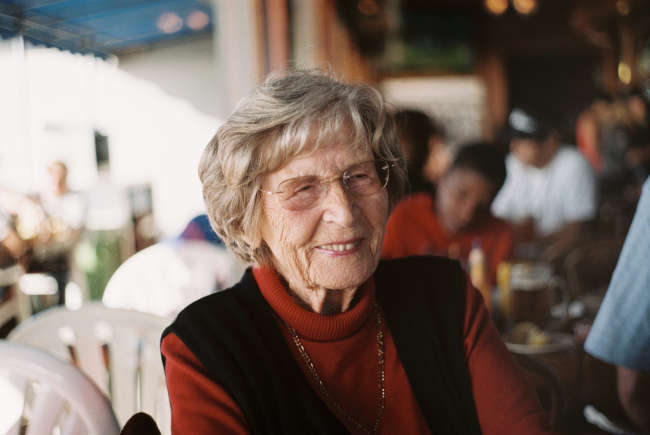 elderly woman sitting in coffee shop and smiling