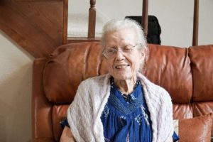 elderly woman sitting on couch at home