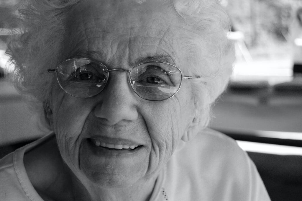 older-woman-smiling-glasses-black-and-white